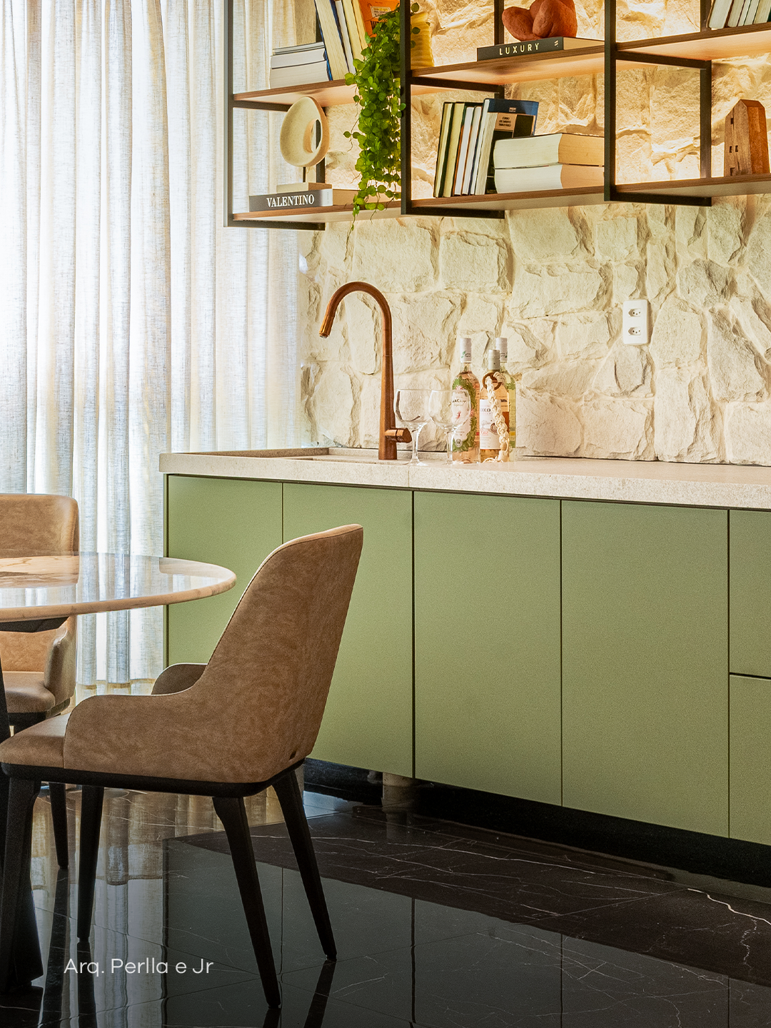 Espaço com marcenaria verde sofisticada, pedra texturizada e prateleiras iluminadas.